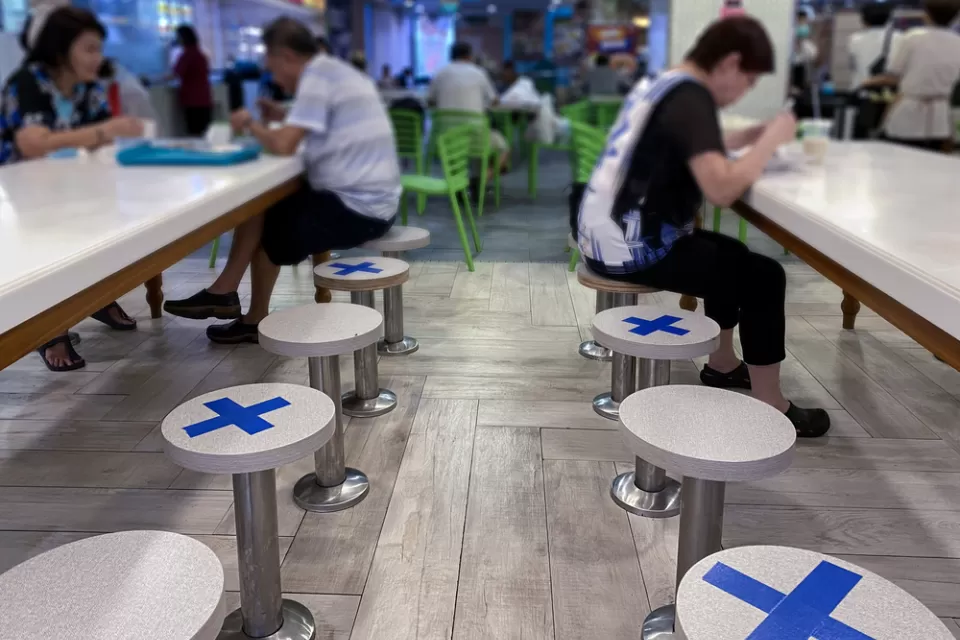 A restaurant in Singapore places tape on seats to maintain distance between diners during the Covid-19 pandemic in 2020.